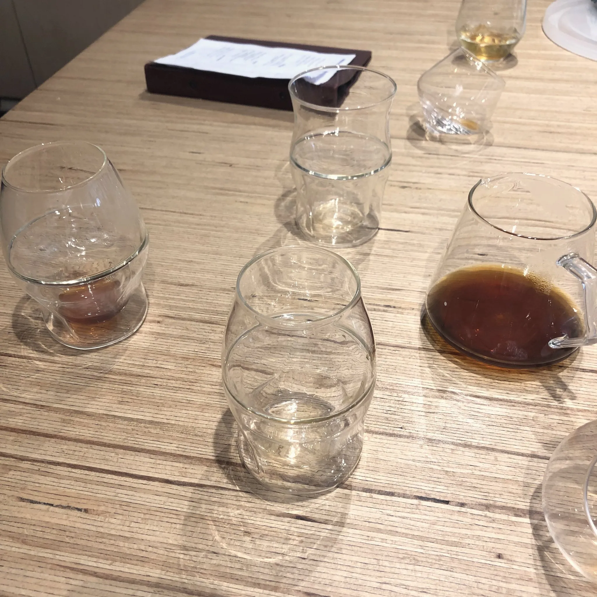 Small glasses of coffee lined up on a wooden table