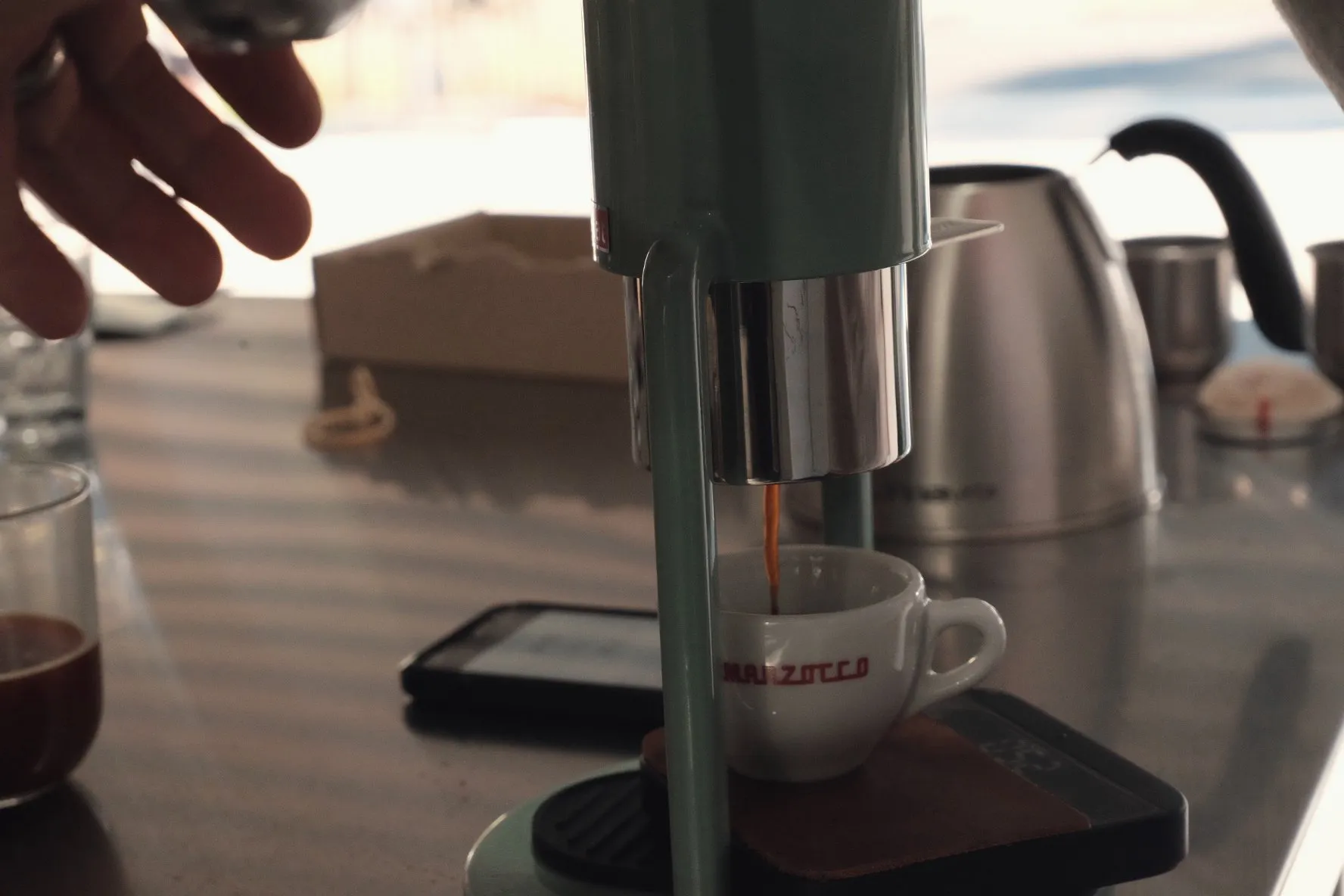 A manual lever espresso machine brewing by the water